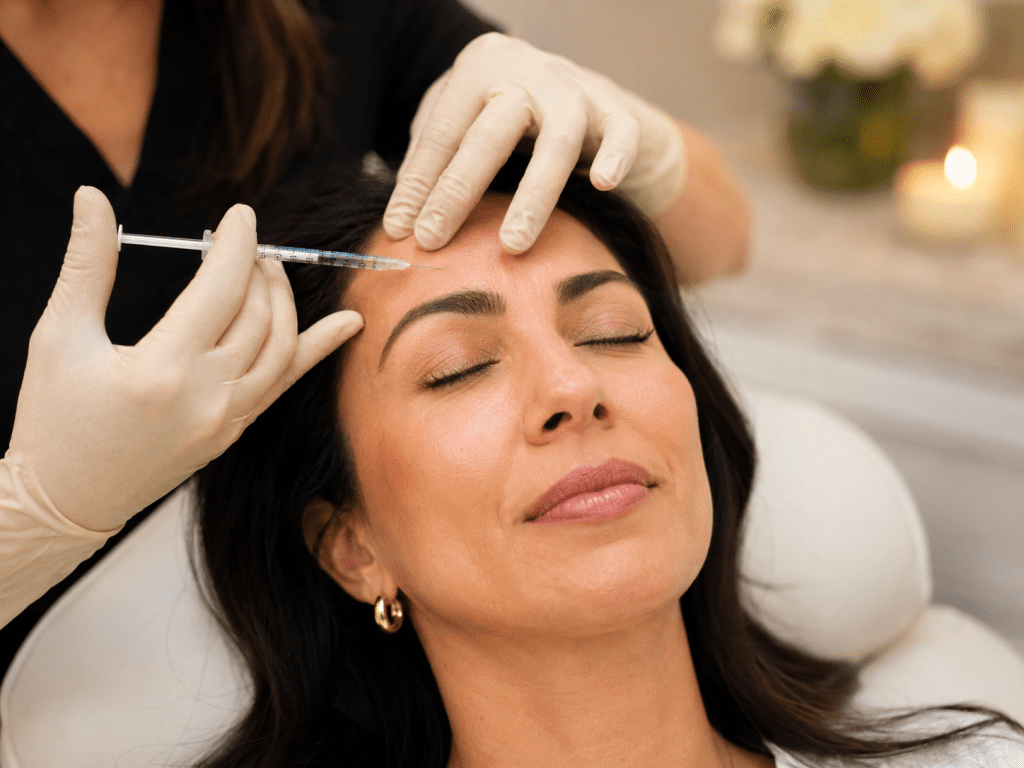 Board-certified injector administering Botox treatment to patient's forehead at FACE/FIT Houston, TX